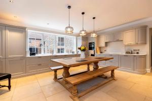 a kitchen with a wooden table and a vase of flowers at The Vicarage in Billingham