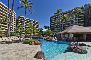 a resort swimming pool with chairs and palm trees at Kaanapali Alii 456 · ALII 456 OceanFront Tropical Getaway w Ocea in Kaanapali
