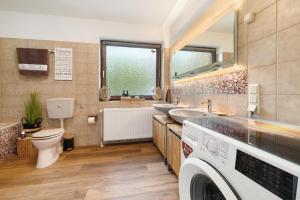 a bathroom with two sinks and a toilet in it at Ferienhaus Kribbikrabba Butjadingen in Butjadingen +29 photos