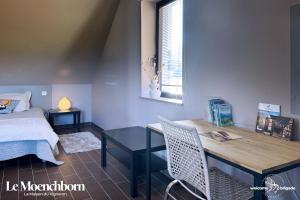 1 dormitorio con escritorio, 1 cama y 1 mesa en Le Moenchborn - la Maison des Vignerons, en Orschwiller