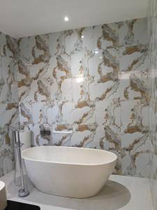 a white bath tub in a bathroom with a stone wall at The Green Sidemen in Silebeng +37 photos