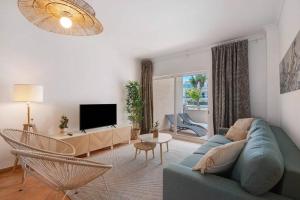 a living room with a blue couch and a tv at Apartamento T2 Santa Luzia - D in Santa Luzia