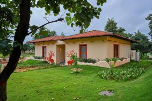 a house with a green lawn in front of it at Hotel Sonar Bangla Ajodhya Hills in Purulia