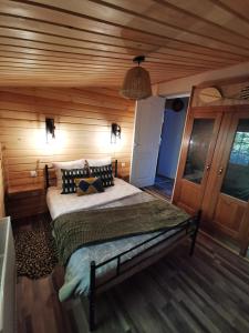 a bedroom with a bed in a wooden room at Chalet - gîte avec étang in Deneuvre