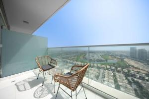 two chairs and a table on a balcony with a view at StayShort - Damac Hills Sleeps 3 close to Golf Courses in Dubai Marina