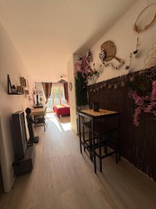un salon avec une table et une télévision dans l'établissement Lescale Zen de Bailly, à Bailly-Romainvilliers