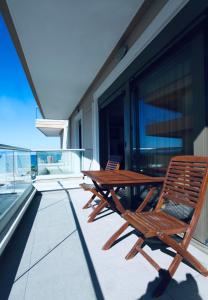 a wooden table and chairs on a balcony at The little palace next to the sea in Rethymno Town
