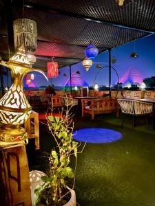 Un patio con una mesa y sillas con luces moradas. en Farsha Pyramids Inn, en El Cairo