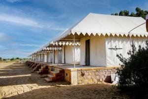 斋沙默尔Desert Capital Resort的一个白色的大帐篷，前面有木头