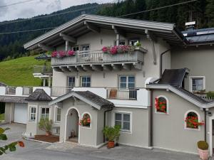 una gran casa blanca con flores en los balcones en Apartment Kerer, en Wald im Pinzgau