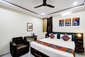 a hotel room with a bed and a chair at FabHotel O PNR Continental in Hyderabad