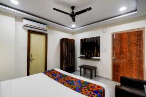 a bedroom with a bed and a ceiling fan at FabHotel O PNR Continental in Hyderabad
