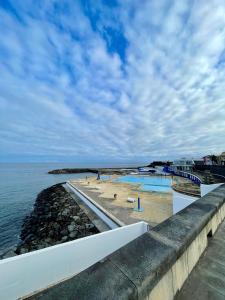 eine Reihe von Schwimmbecken neben dem Wasser in der Unterkunft Canto da Maré in Ribeira Grande