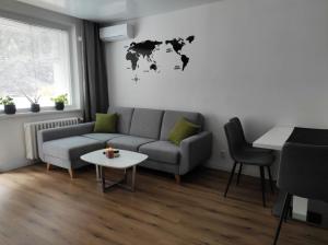 a living room with a couch and a world map on the wall at Moderný apartmán pri lesoparku in Košice +1 photo