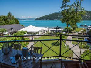 a view of the lake from the balcony of a resort at Les Roseaux du Lac - 7 appartements situés dans une résidence posée au bord du lac d'Annecy in Duingt