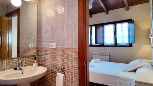 a bathroom with a sink and a bed and a mirror at Apartamentos Rurales Senda Costera in Hontoria +121 photos
