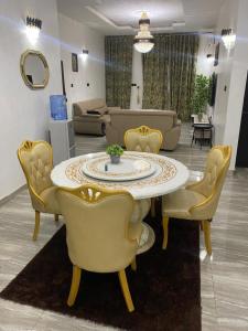 a living room with a table and yellow chairs at Bumcy Apartment in Ankuru