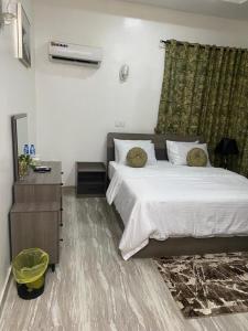 a bedroom with a large bed and a dresser and a bed sidx sidx sidx at Bumcy Apartment in Ankuru