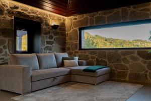 een woonkamer met een bank en een tv bij Casa Encosta do Monte in Póvoa de Lanhoso