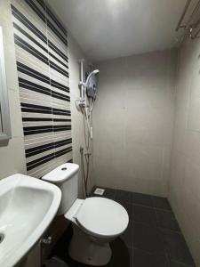 een badkamer met een wit toilet en een wastafel bij JJ Hotel Sitiawan Perak in Sitiawan