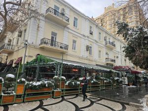 a man is standing in front of a christmas market at Nizami 37 in Baku