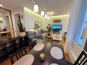 a living room with a dining table and a living room with a tv at Pilies23 Old Town Luxury Apartment in Vilnius