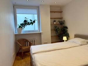 a bedroom with a bed and a window with a plant at Pilies23 Old Town Luxury Apartment in Vilnius