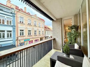 a balcony with tables and chairs and a building at Pilies23 Old Town Luxury Apartment in Vilnius