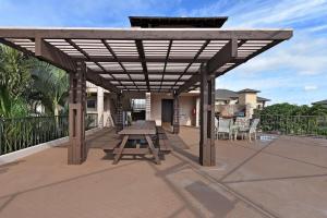 a picnic table under a wooden canopy on a patio at Kihei Alii Kai A207 · KAK A207 Renovated Kihei Condo Near Beach in Kihei