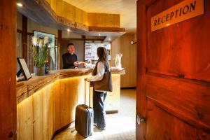 a man and a woman standing at a bar at Logis Hôtel Au Gai Soleil du Mont-Aiguille in Chichilianne