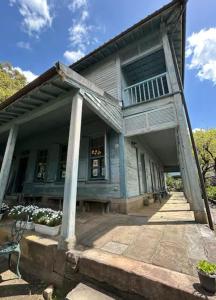 una casa antigua con un gran porche y un porche en ゲストハウス, en Nagasaki