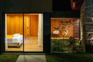 een uitzicht op een slaapkamer vanaf de buitenkant van een huis bij Casa Encosta do Monte in Póvoa de Lanhoso +22 foto's