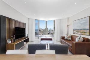 Una sala de estar con un sofá y un televisor. en Ashley On Beach 1104 Prestige Style, en Strand