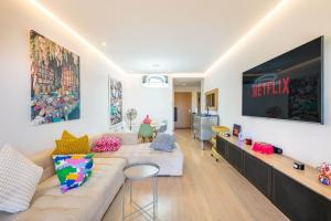 a living room with a couch and a tv at Appartement luxe Prestige Opale Golf in Marrakech