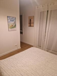 a bedroom with a bed and a window at 2 chambres, avec balcon, à 8 min des plages en voiture in Plérin