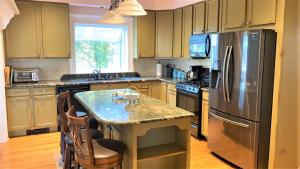 a kitchen with a table and a stainless steel refrigerator at Marlin House in Cape May