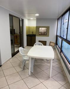 イタペマにあるApartamento Meia Praiaの白いテーブルと椅子 +5枚の写真