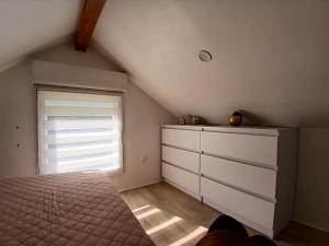 a bedroom with a bed and a dresser and a window at Petite Maison in Saint-André-les-Vergers