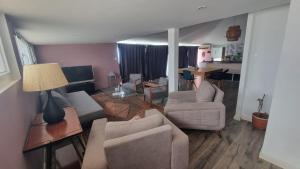 Una sala de estar con un sofá y sillas y una mesa. en dareddroudj, en Staoueli