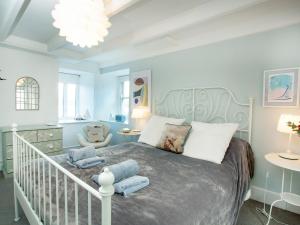 a bedroom with a bed with blue walls and a chandelier at The Lookout in Polruan