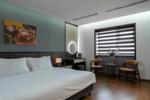 a bedroom with a bed and a desk and a window at Luxe Paradise Hotel Nguyen Khac Hieu in Hanoi