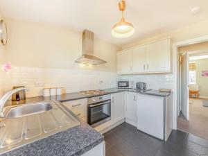 a kitchen with white cabinets and a sink at South Lodge - Uk48318 in Berwick-Upon-Tweed