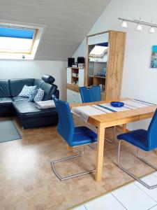 a living room with a table and blue chairs at Haus Oettinger in Hayingen