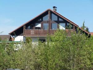 a house with a deck on top of some trees at Haus Oettinger in Hayingen