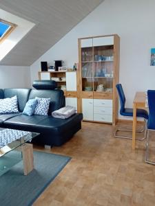 a living room with a blue couch and a table at Haus Oettinger in Hayingen +18 photos