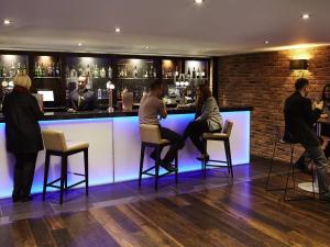 un groupe de personnes assises à un bar dans l'établissement Novotel Coventry, à Coventry