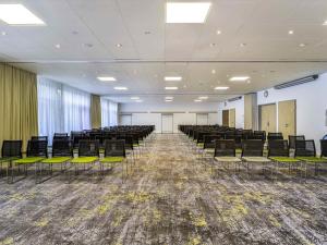an empty room with chairs and tables and a room with at Novotel Poznań Malta in Poznań +170 photos