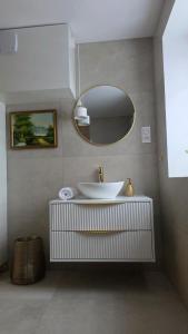 a bathroom with a white sink and a mirror at Kominkowy Zakątek in PyzÃ³wka