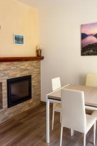 a dining room with a table and a fireplace at Casa Perla dei Laghi - Lake View, BBQ, WiFi 1Gb & AirCond in Porlezza