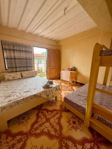 ein Schlafzimmer mit zwei Etagenbetten und einem Tisch in der Unterkunft JJL pension house in Siquijor